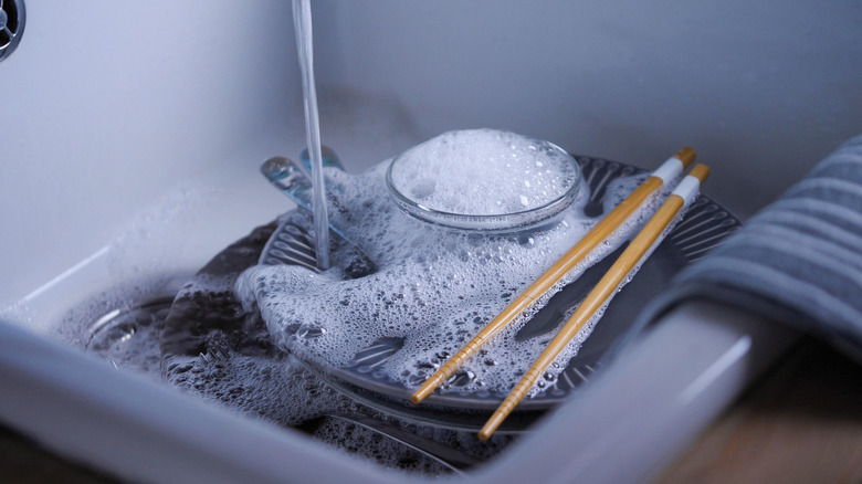 Dishes in sink with soapy water