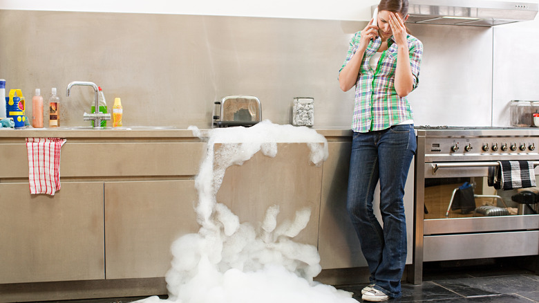 Woman staring at dishwasher suds