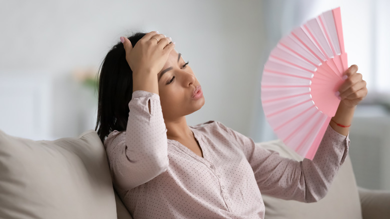 Woman fanning herself on couch