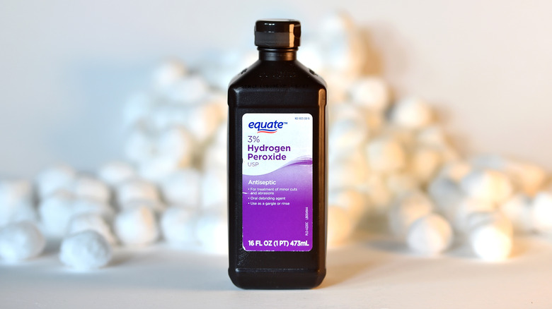Bottle of hydrogen peroxide with cotton balls