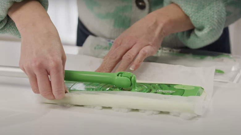 person installing Swiffer cloths
