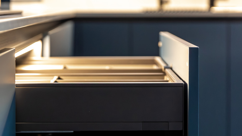 A deep blue kitchen drawer that is pulled out