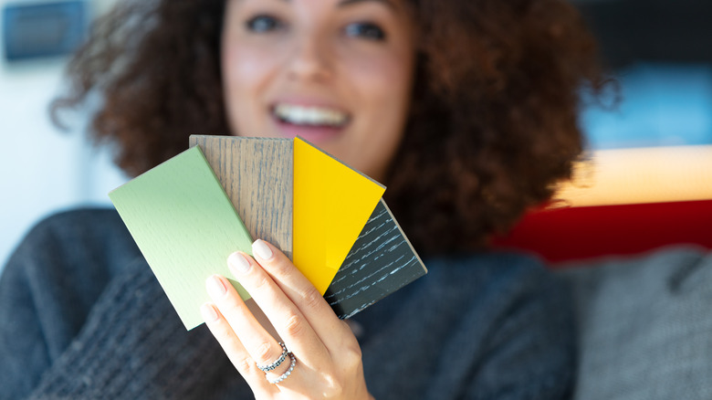 Smiling woman holding paint swatches