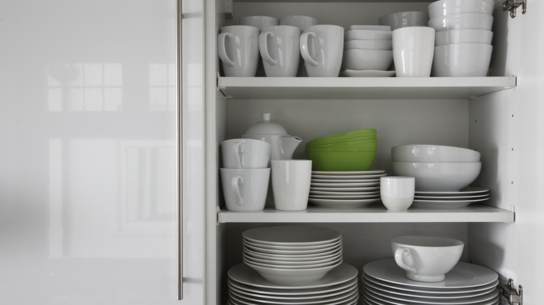 Mugs and crockery in cupboard