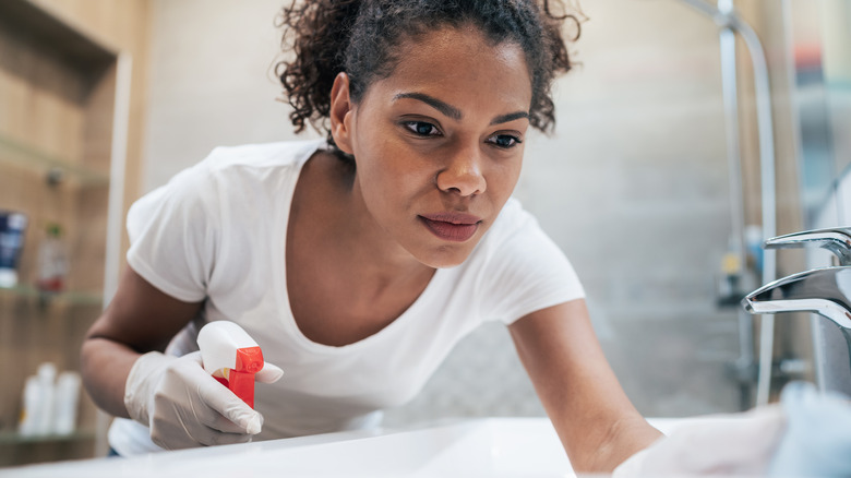 Woman focused while cleaning bathroom