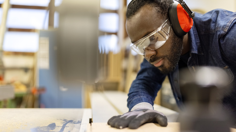 Man cutting wood using protection