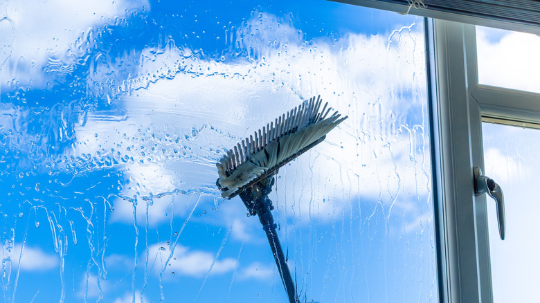 Brush cleaning outside window on a cloudy day