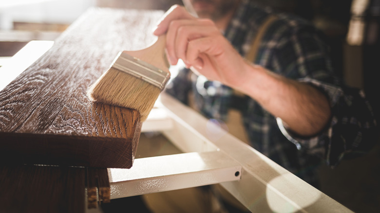 Person staining wood board