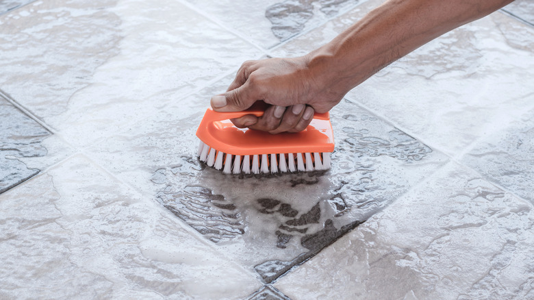 A person scrubbing tile floors