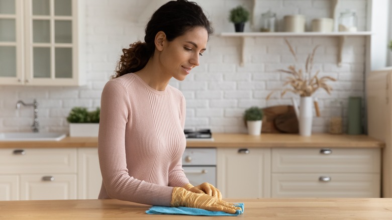 woman cleaning wood countertop