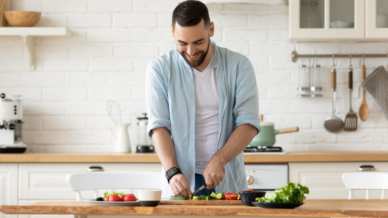 man chopping on wood countertop