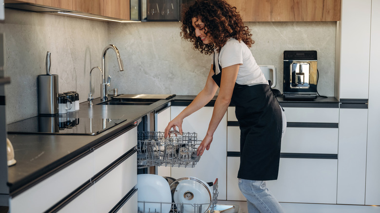 Woman loading a dishwasher in a modern kitchen
