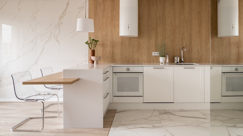 A bright, high end home kitichen with white marble floors.