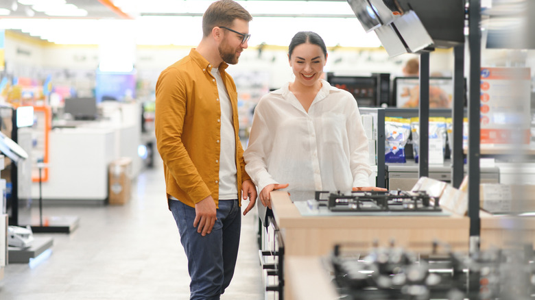 A man and a woman shopping for kitchen appliances