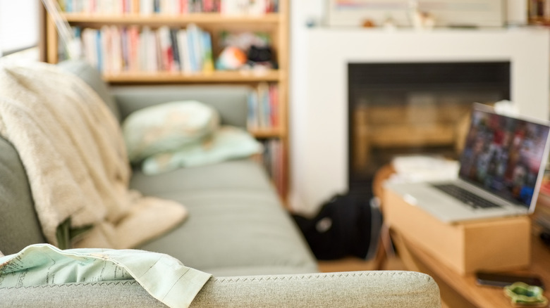 Living room with a couch and a laptop on a wooden table.