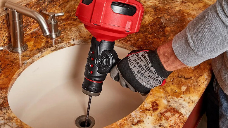 Unblocking a sink drain with Bauer's electric drain cleaner