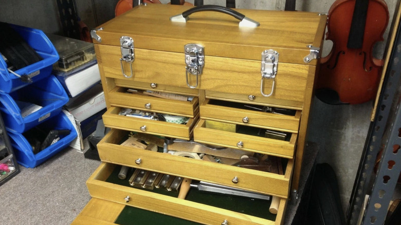A wood Harbor Freight tool chest holding small items