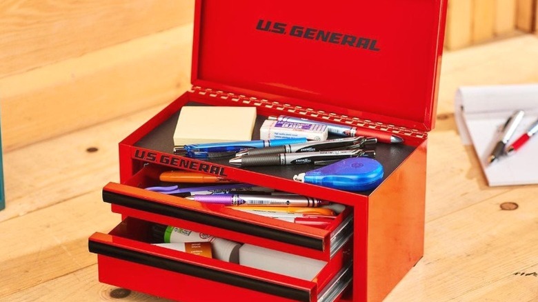 Red U.S. General mini toolbox full of writing utensils on wood counter