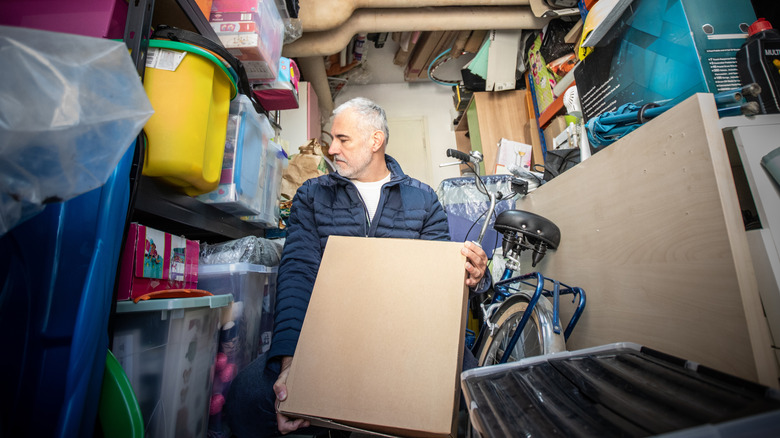 A man trying to organize a cluttered garage