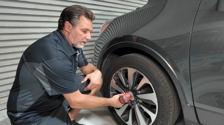 Man using a Milwaukee impact wrench on lug nuts
