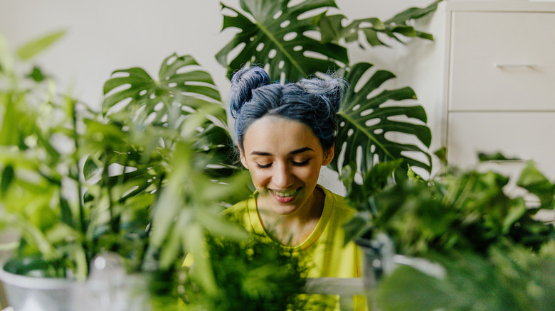 a young woman taking care of her indoor plants