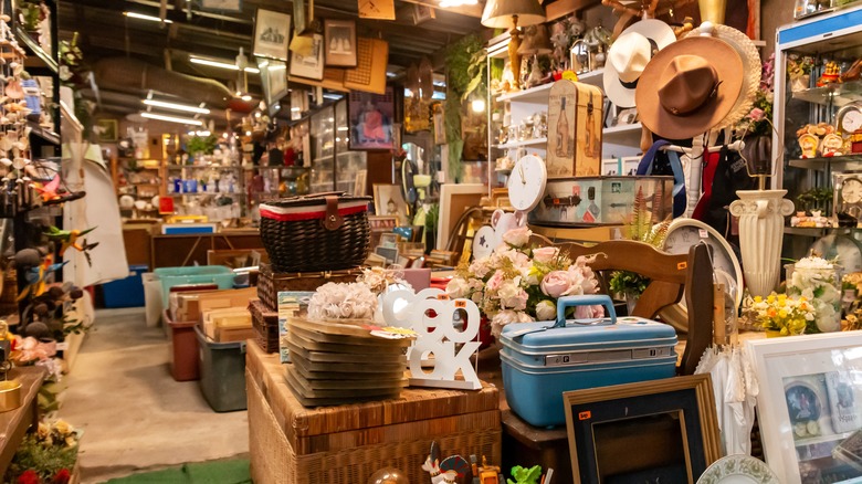 An aisle of a second-hand store with lots of items on display