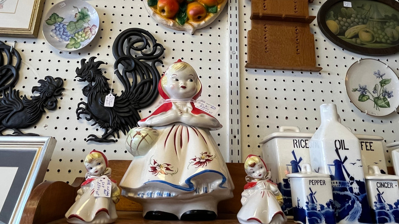 A shelf of vintage cookie jars in a thrift store.