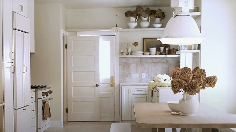 A bright white kitchen with dried flowers.