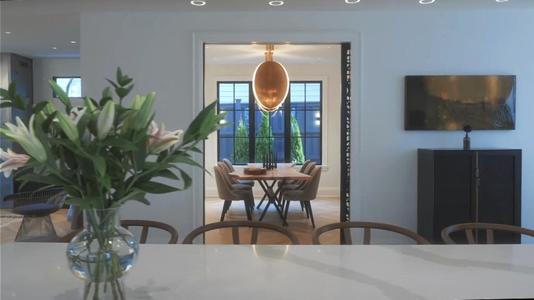 A marble countertop with a view into a modern dining room.