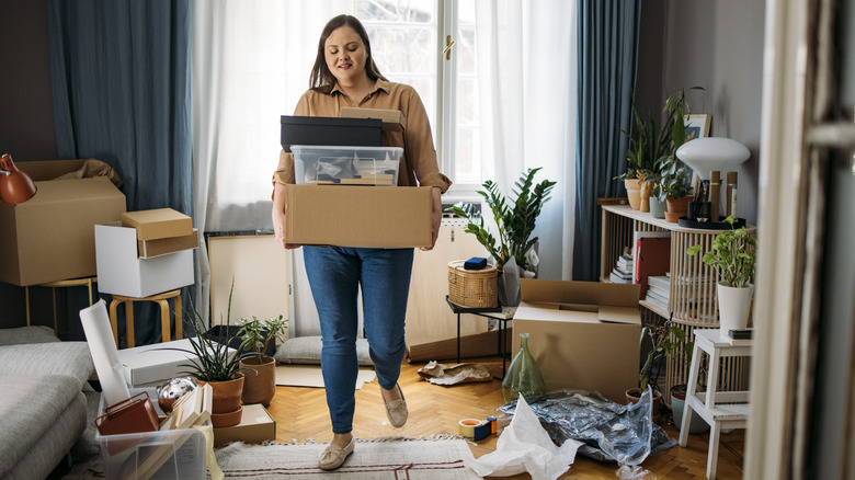 Woman with boxes cluttered room