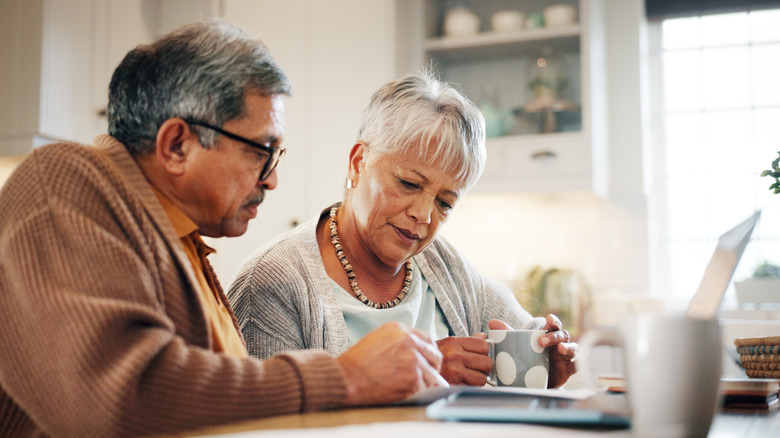 A mature couple looks over a bill