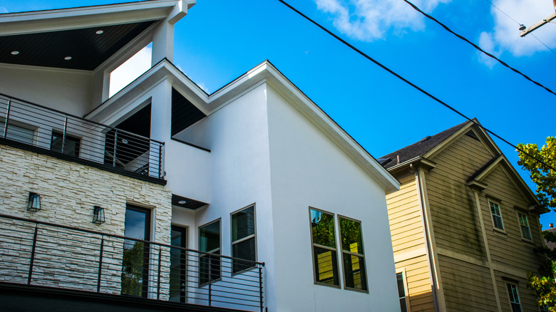 Modern home rebuild next to older, original home in neighborhood