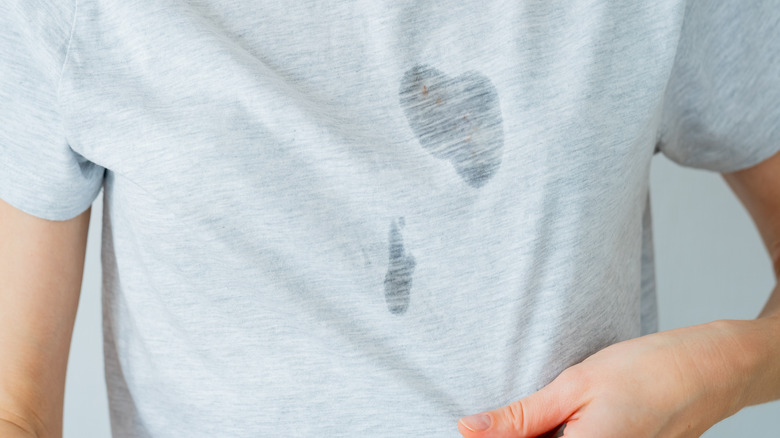 woman notices shirt's oil stain