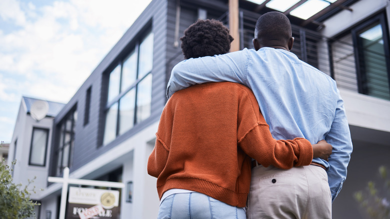 A happy couple admires their new home.
