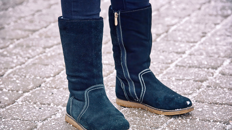 Winter boots on floor with ice melt salt