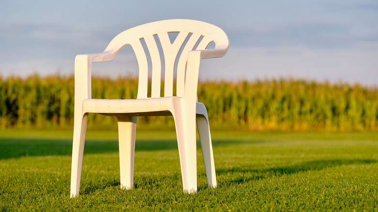 A monobloc plastic chair in a feild