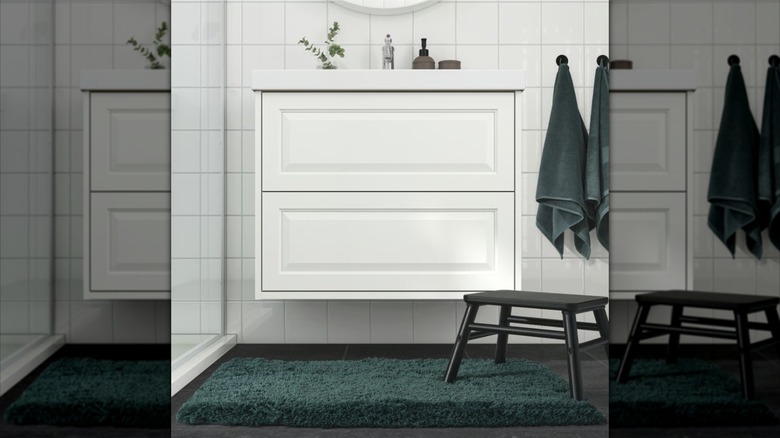 gray-turquoise mat from IKEA in a bathroom setting with towels and soap dispensers to match