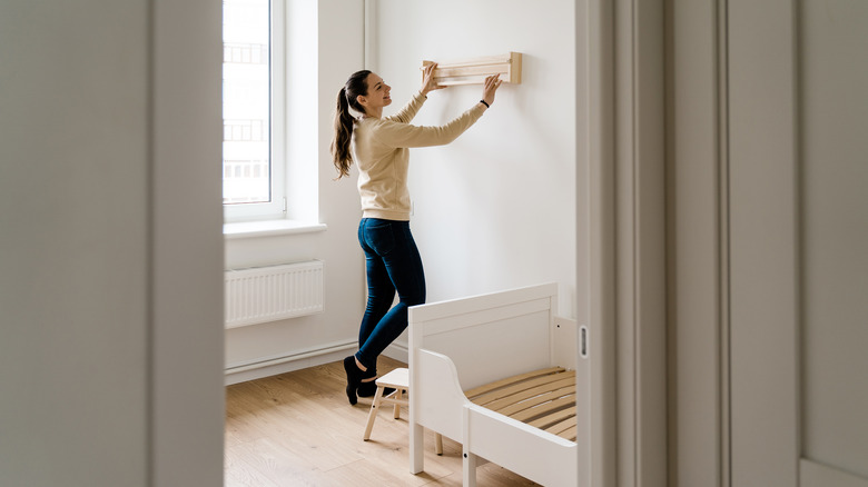 woman hanging floating shelf