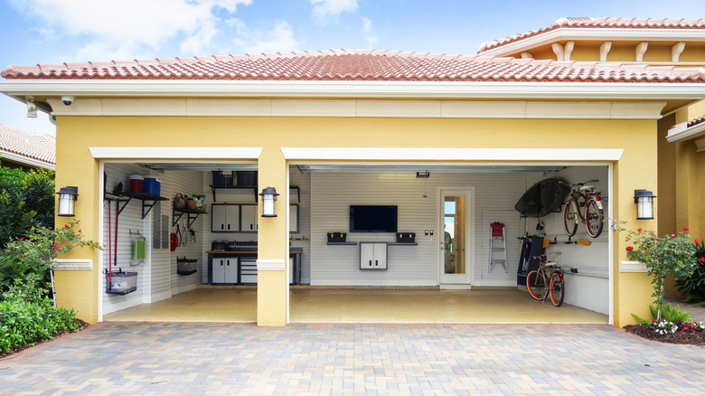 A yellow house with an organized garage.