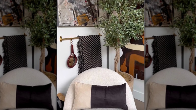 IKEA rail hung on living room wall with blanket and decor hanging from it.