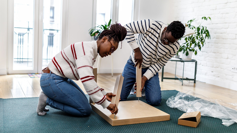 two people assembling table