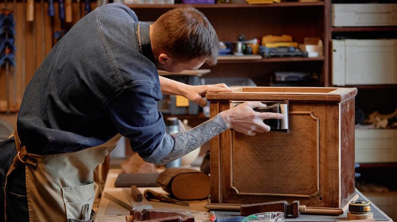 A man refurbishing a vintage cabinet