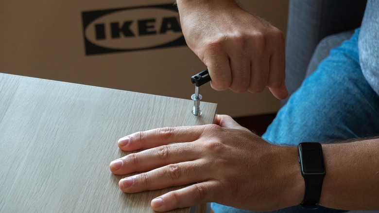 man building ikea furniture