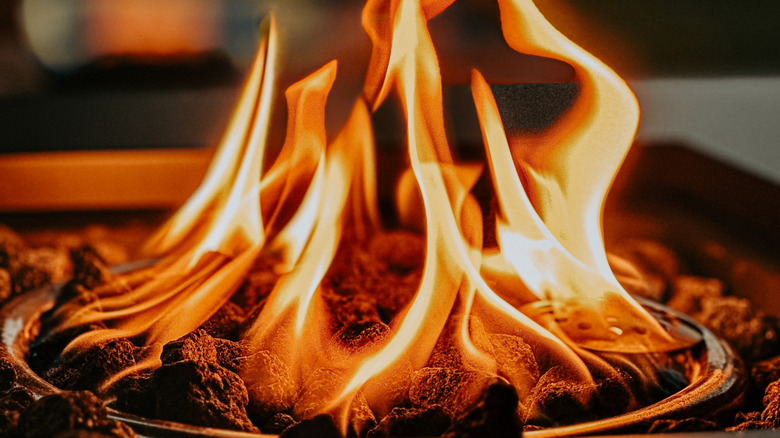 A happy couple on a patio enjoying the warmth from a built-in fire pit