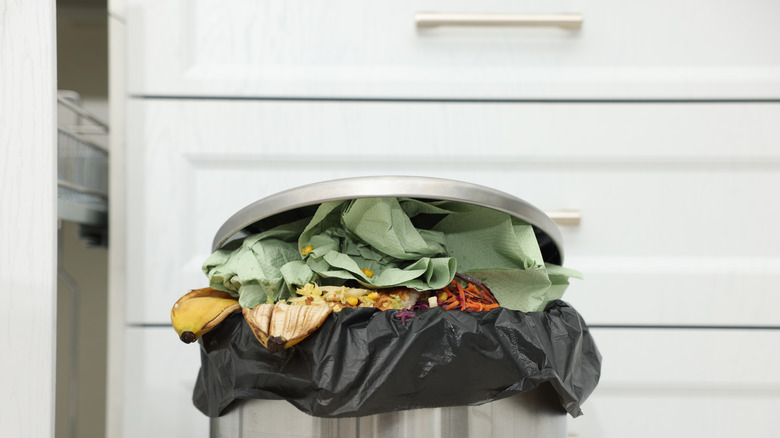 Overfilled trashcan in kitchen