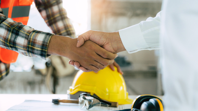 A contractor and a client shaking hands over a deal.