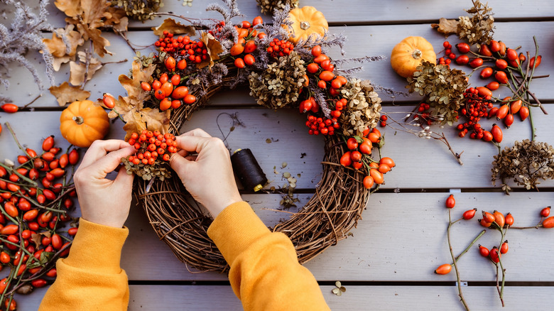 woman makes autumn wreath