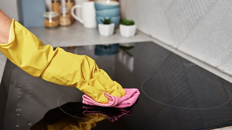person cleaning electric stovetop