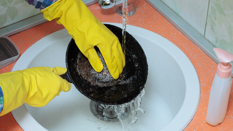 Person cleaning cast iron pan