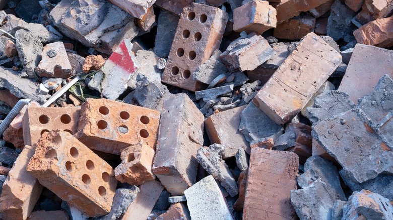Broken bricks, roof tiles, and concrete debris lay in a big pile.